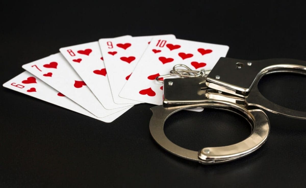 Five cards including a six, seven, eight, nine and 10 of hearts, sitting next to a pair of handcuffs.