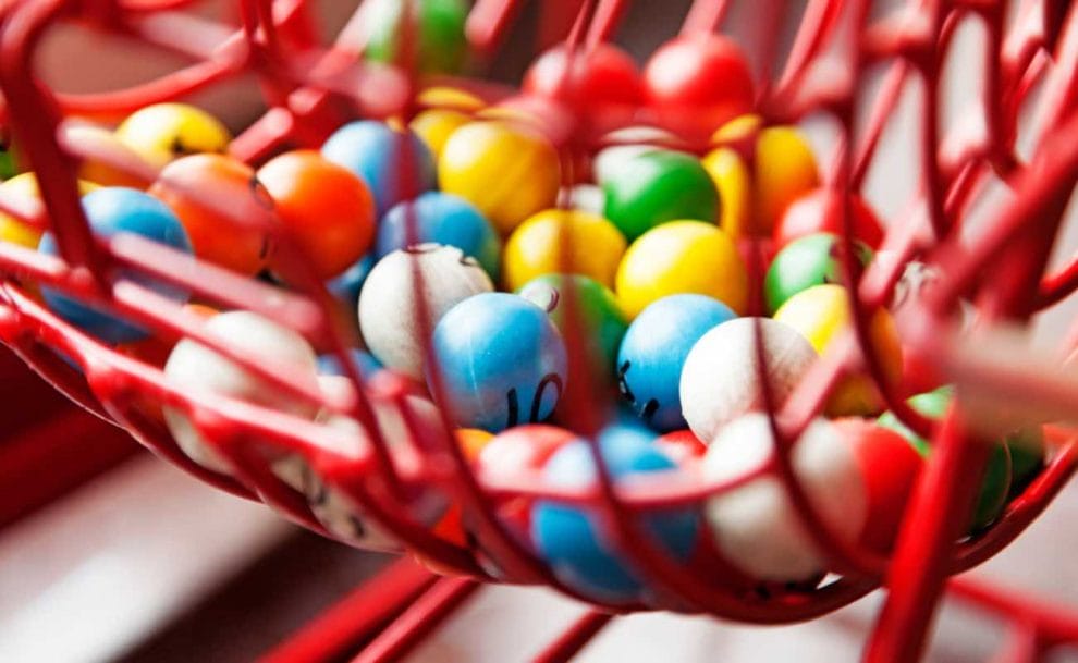 A bingo cage with bingo balls inside of it. 