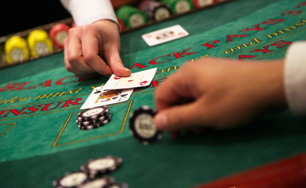 A dealer placing a card on a blackjack table.