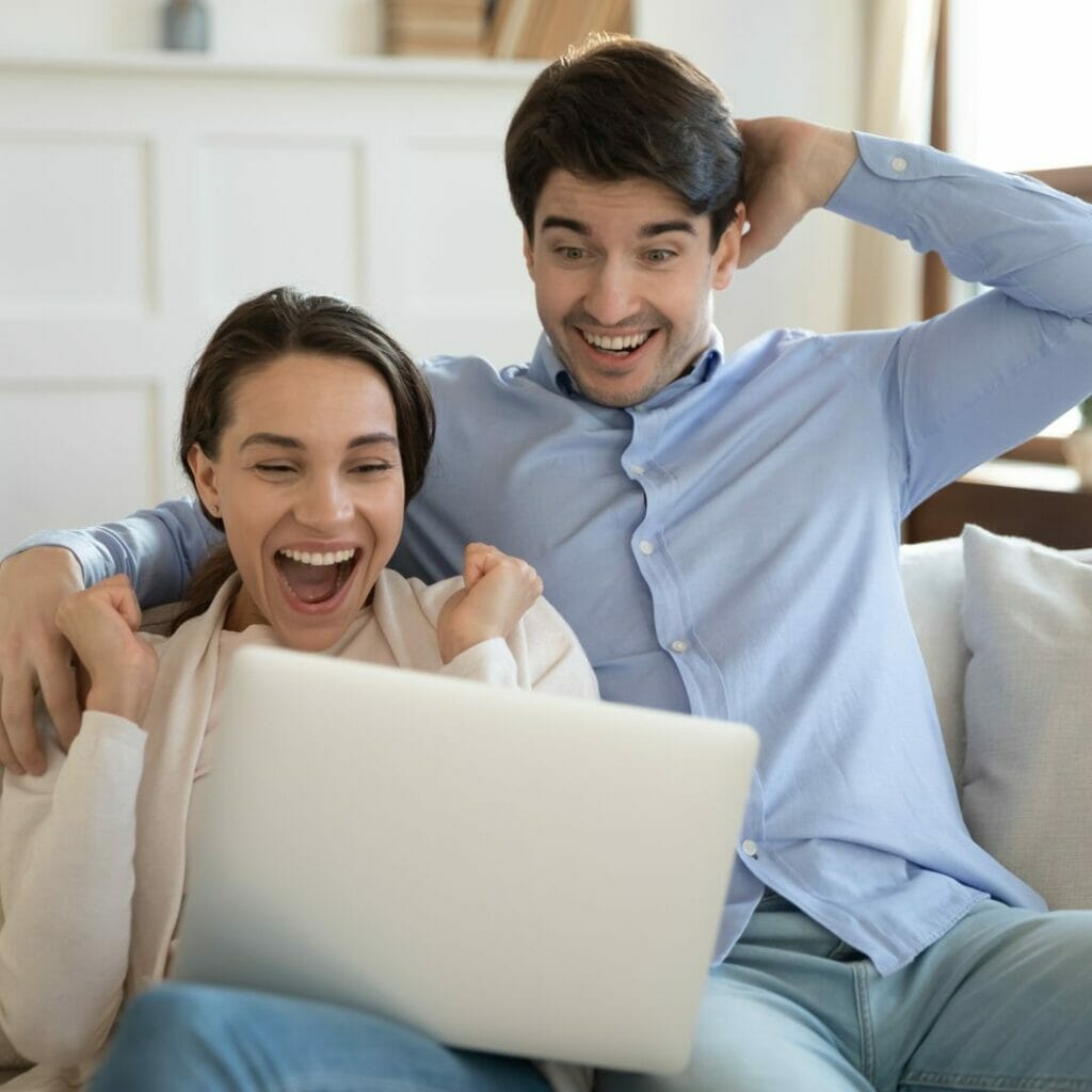Two people cheer while hugging.