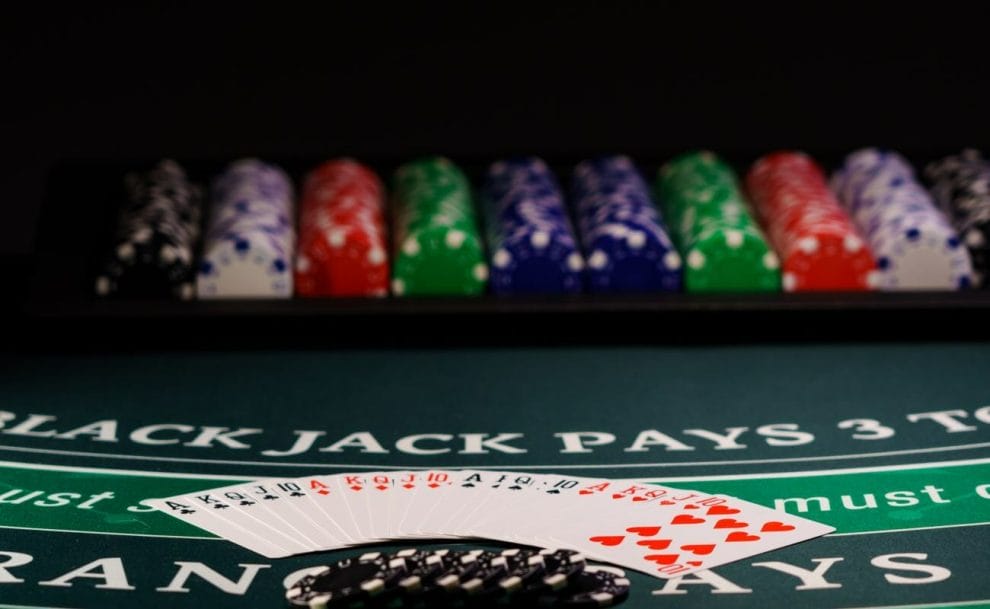 Blackjack table with casino chips and playing cards.