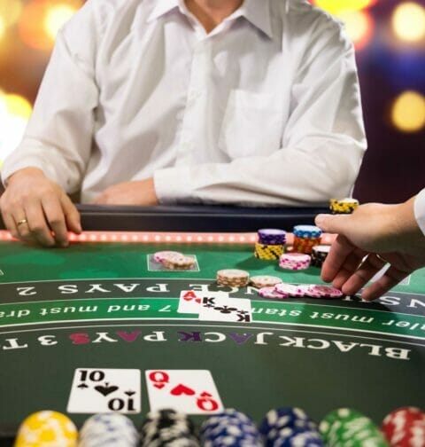 A dealer taking a blackjack player’s bet.