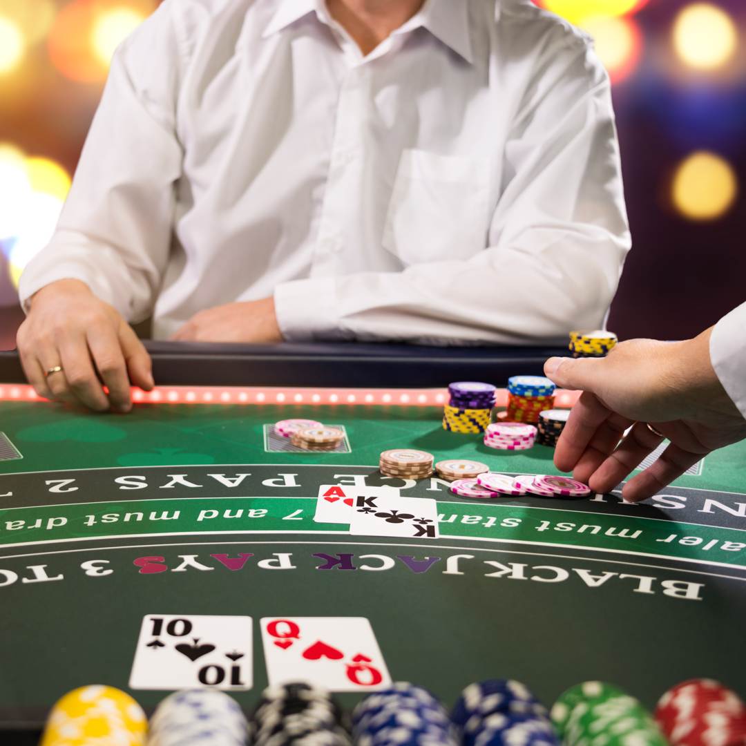 A dealer taking a blackjack player’s bet.