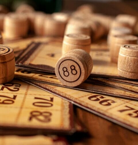 Wooden bingo pieces and cards on a table.