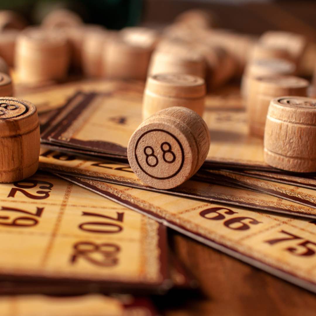 Wooden bingo pieces and cards on a table.