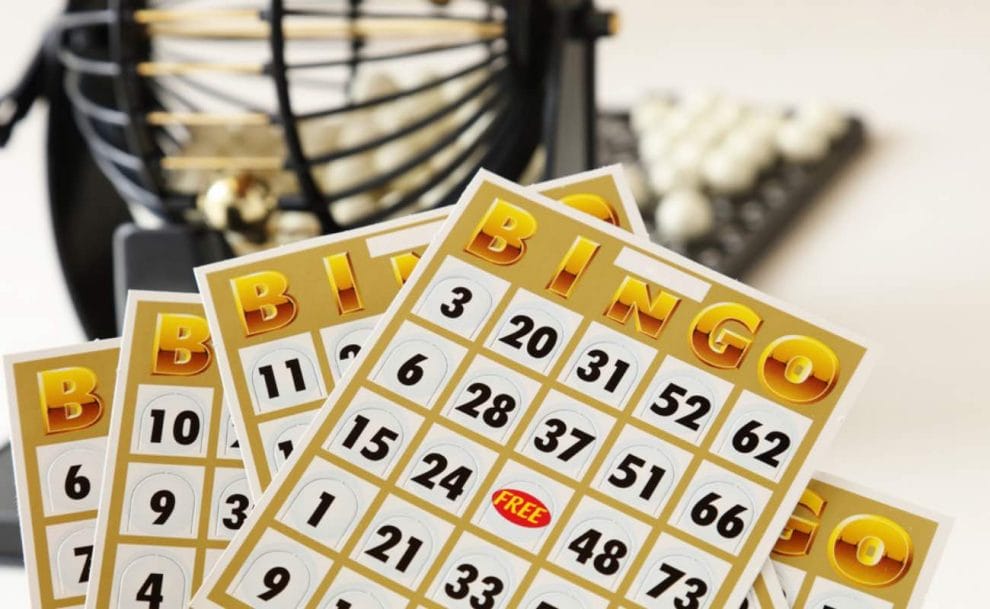Bingo cards in front of a bingo cage.