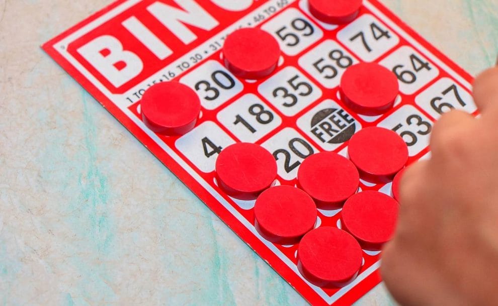 A player marking numbers on a bingo card with bingo markers.