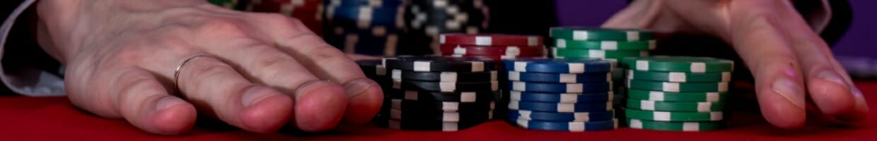 A person slides a stack of chips across the poker table.