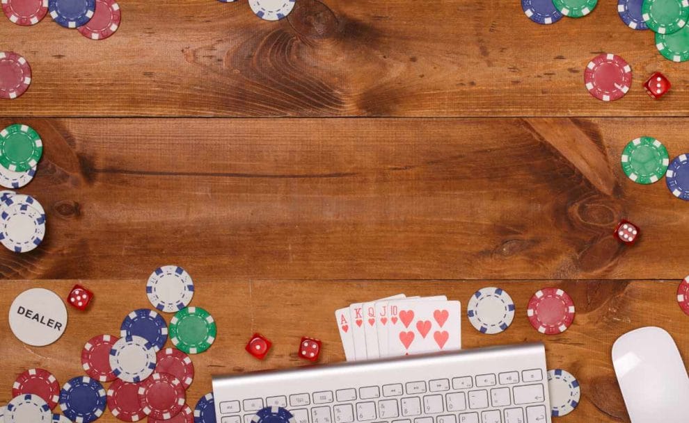 Wooden table with casino chips and keyboard.