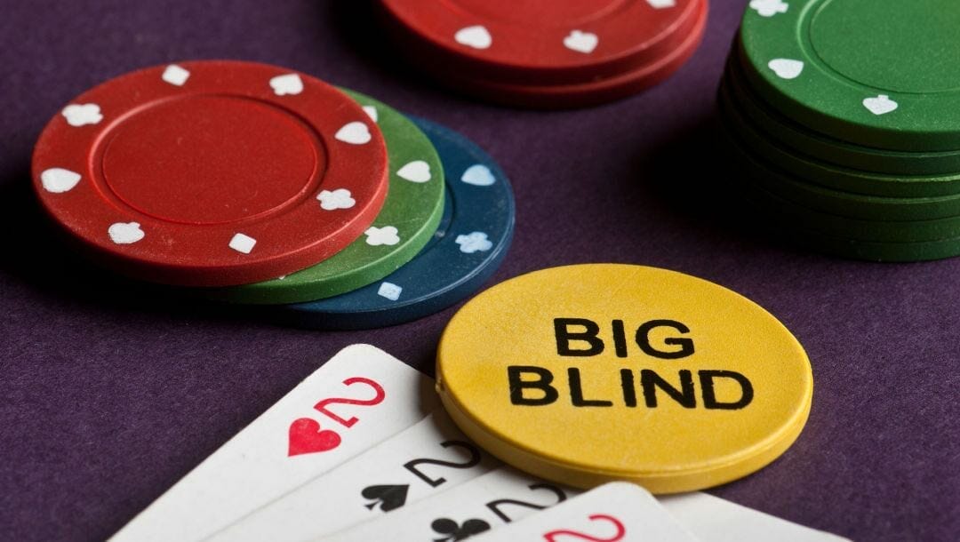 A big blind chip next to some cards and chips.