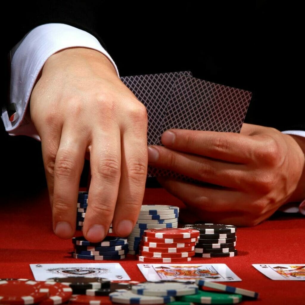 A poker player picks up chips to place their bet.