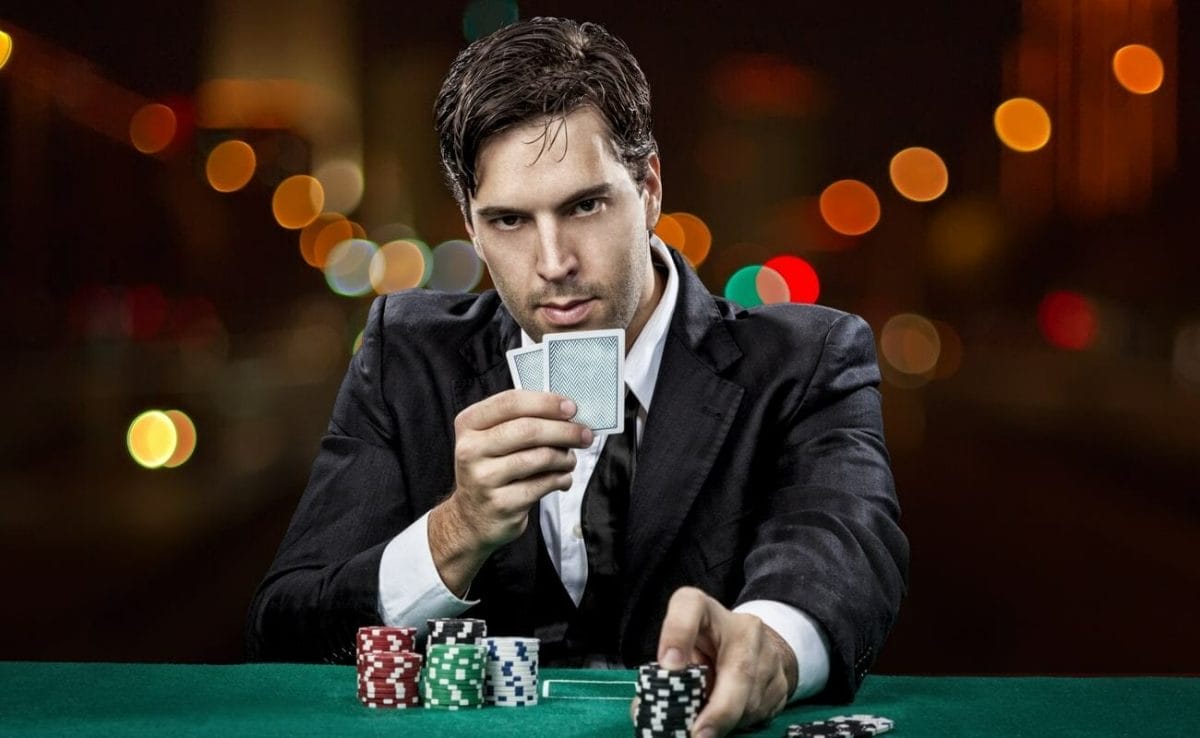 A poker player places a bet while holding their hold cards.