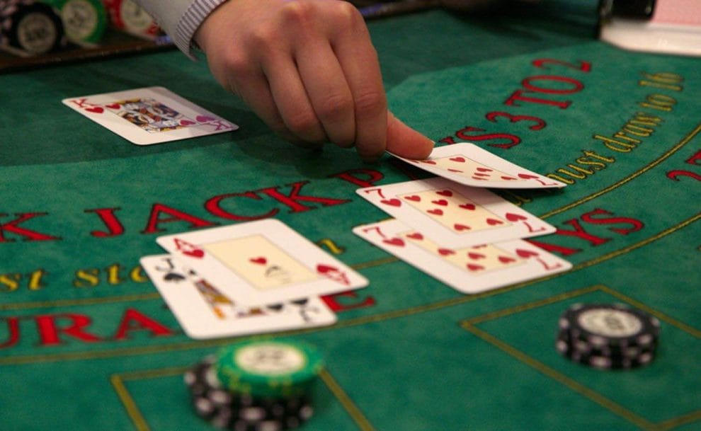 A dealer placing cards down on a blackjack table.