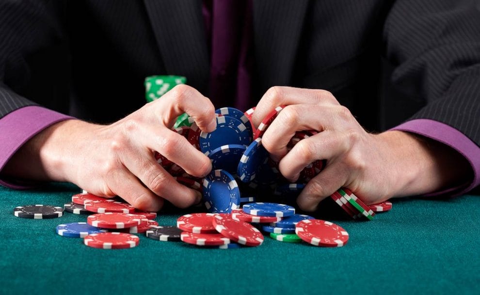 A poker player angrily clutches their poker chips.