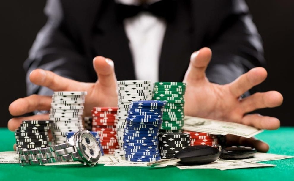 A poker player goes all in. Their bet includes poker chips, cash, their car keys and their watch.