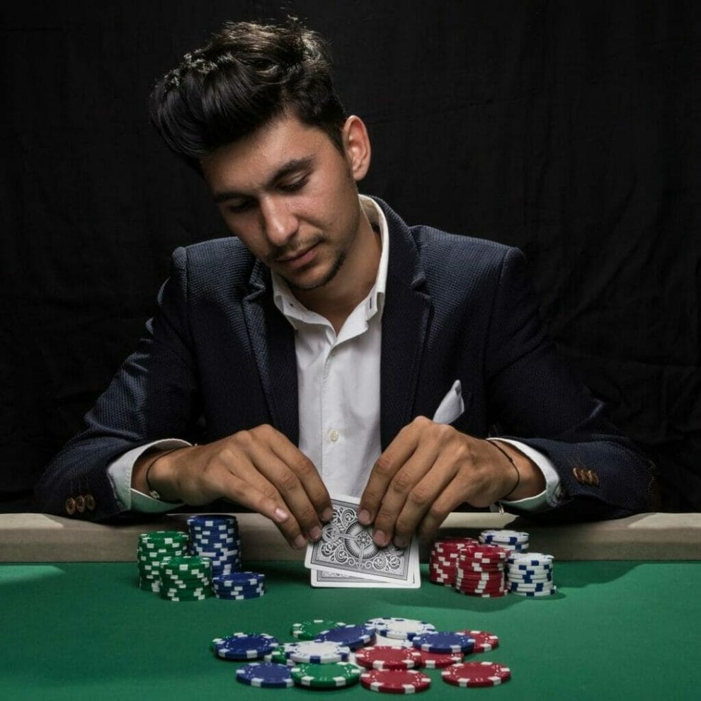 A poker player checks their hole cards.