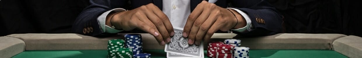 A poker player checks their hole cards.