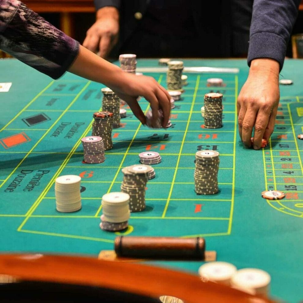 People placing their bets on a roulette table.