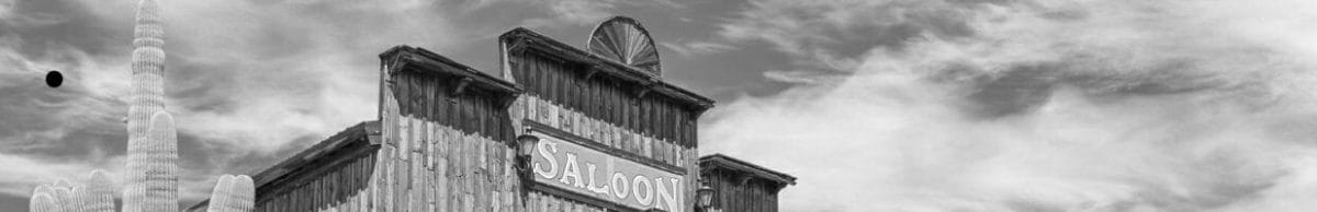 Old Wild West desert town with cactus and saloon.