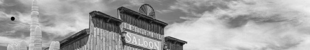 Old Wild West desert town with cactus and saloon.