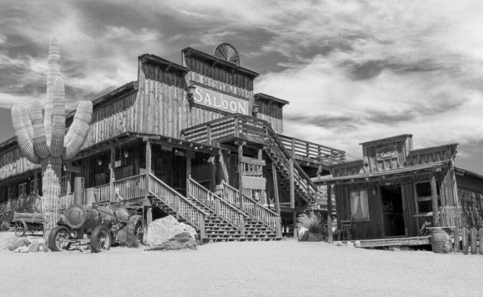 Old Wild West desert town with cactus and saloon.