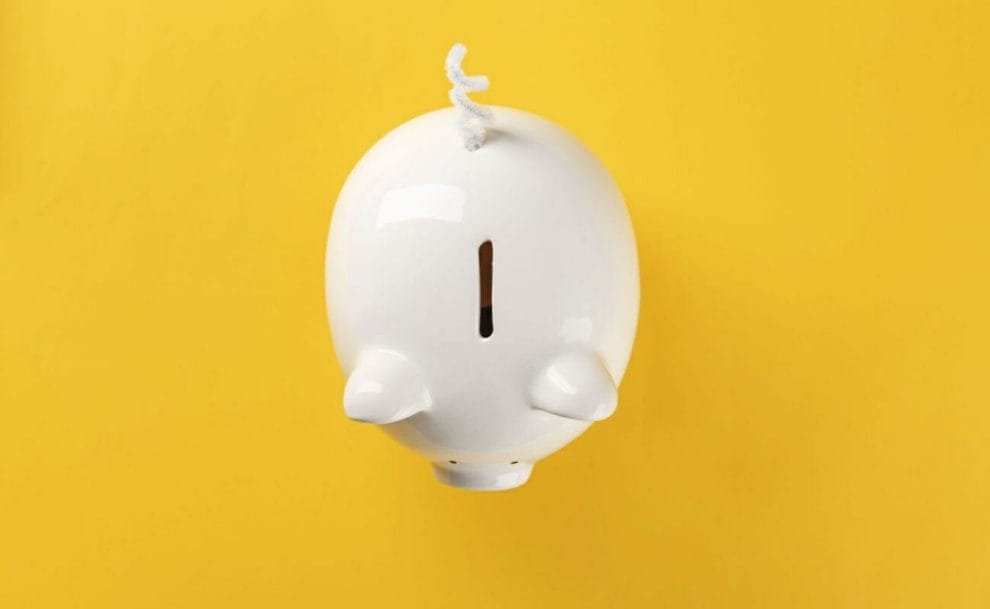 Top view of a white piggy bank on a yellow background.