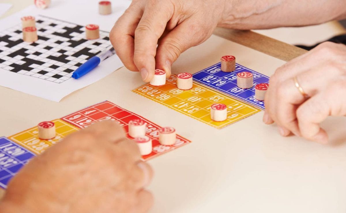 Close-up of bingo players’ hands with the cards and daubers