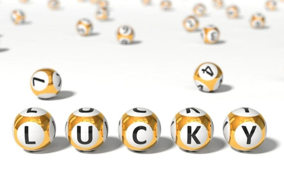 Golden lottery balls spell out the word “LUCKY.”