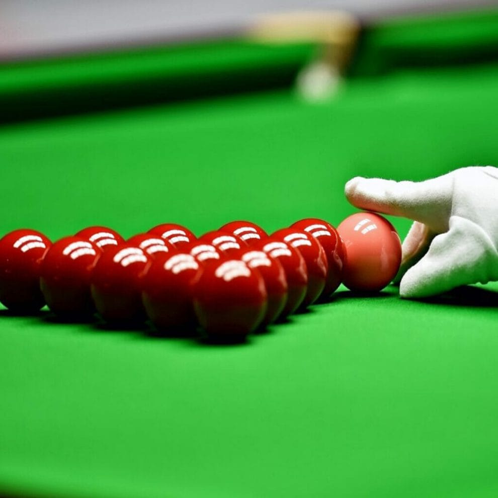 A snooker referee arranges the pink ball