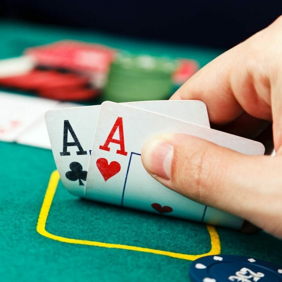 A poker player checks their hole cards.
