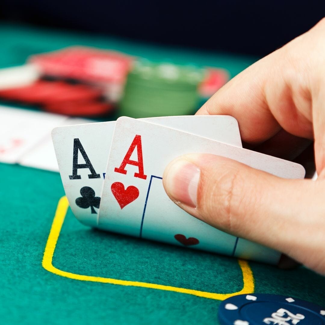 A poker player checks their hole cards.