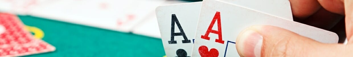 A poker player checks their hole cards.