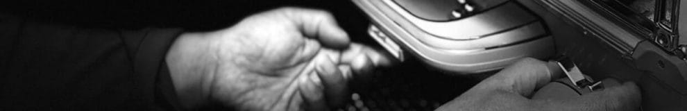 A black and white close-up of a man’s hands while playing pachinko.