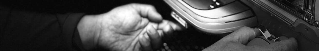 A black and white close-up of a man’s hands while playing pachinko.