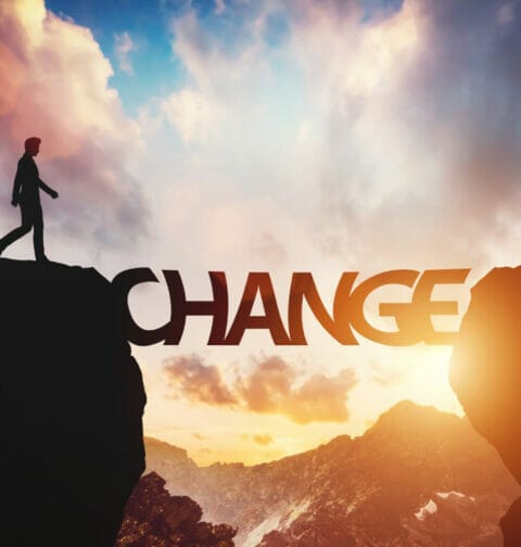The word ‘’change” positioned between two mountain peaks.