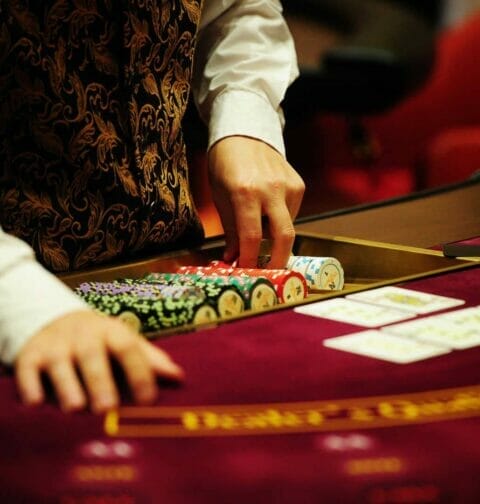 A casino dealer takes out a stack of chips for the table.