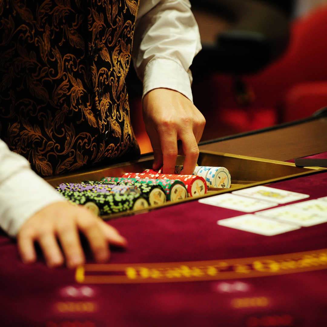 A casino dealer takes out a stack of chips for the table.