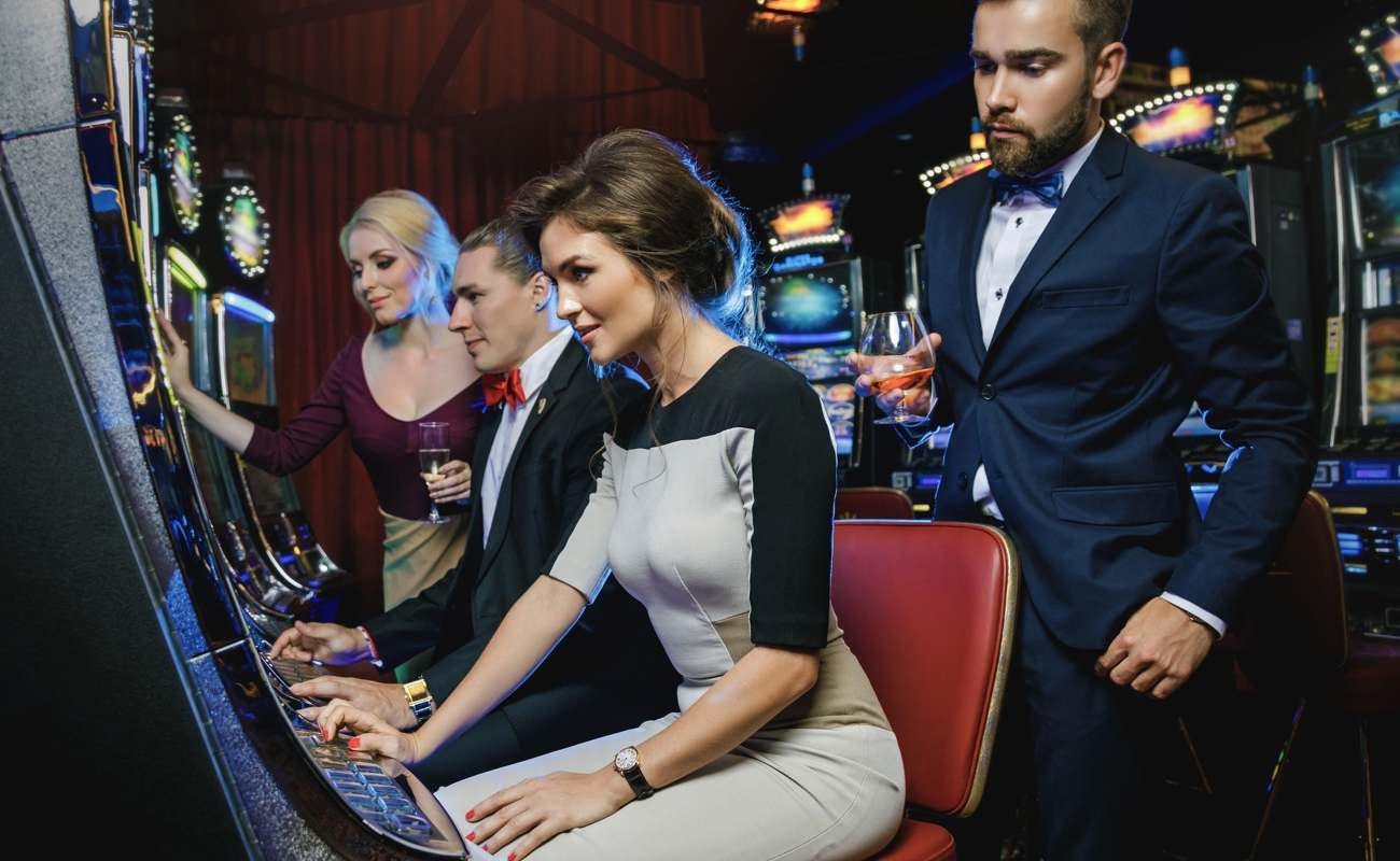 A group of well-dressed friends playing slots at a casino.