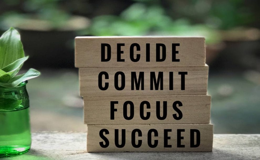 “Decide,” “commit,” “focus” and “succeed” written on wooden blocks.