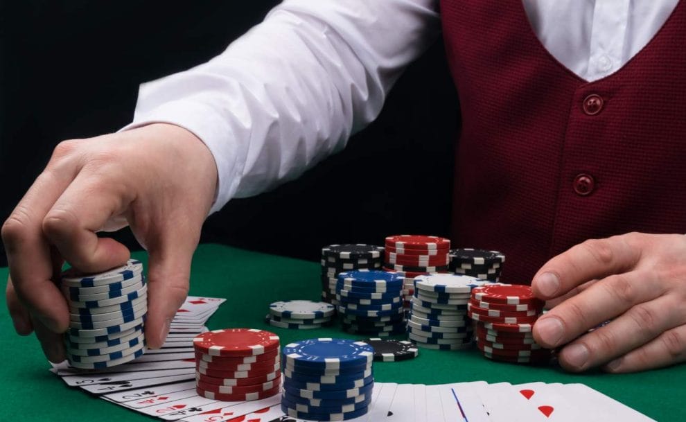 A croupier places poker chips on a poker table.