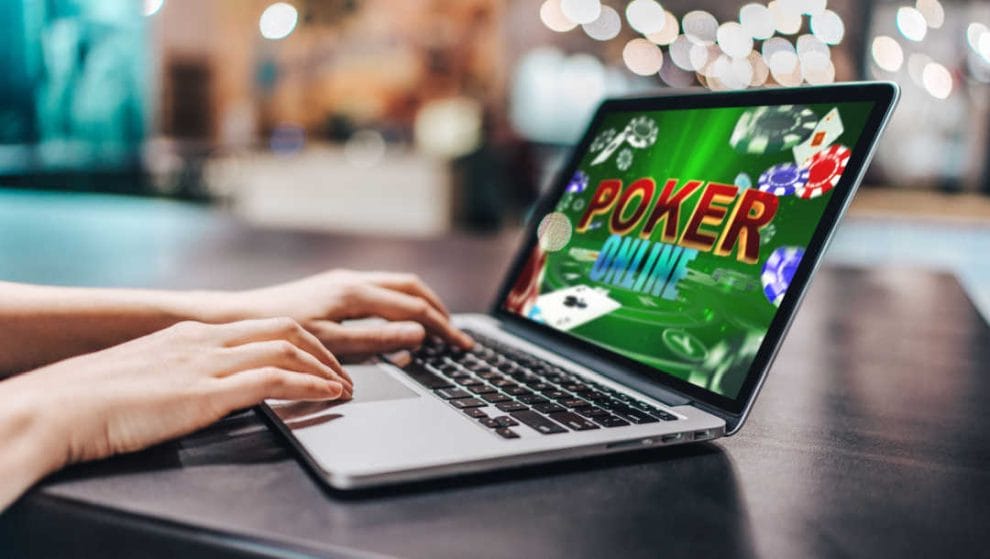A person plays poker online on a laptop.
