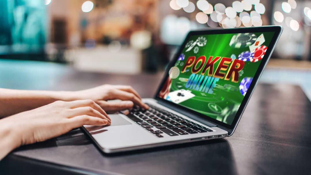 A person plays poker online on a laptop.
