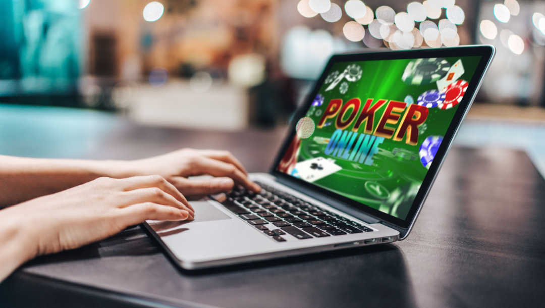 A person plays poker online on a laptop.