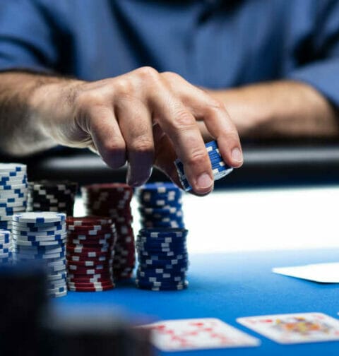 A person places chips down on the poker table.