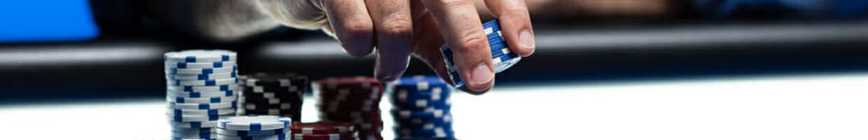 A person places chips down on the poker table.