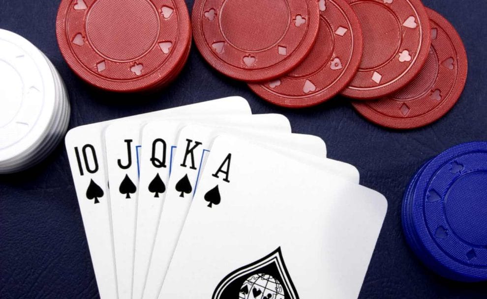 Cards and poker chips on a dark blue table.