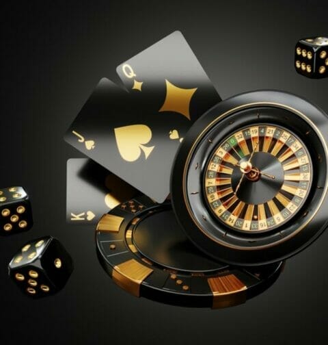 A black and gold roulette wheel, playing cards and dice.
