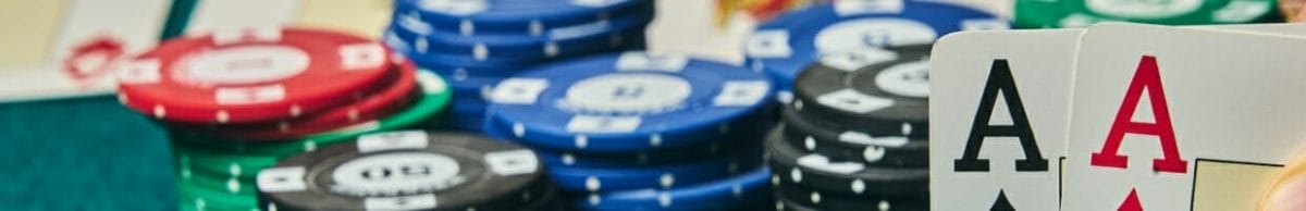 Casino chips and two aces on a poker table.