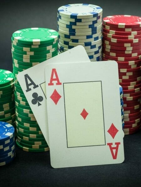 Two aces lean against stacks of poker chips.