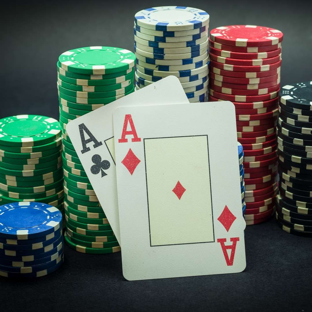 Two aces lean against stacks of poker chips.